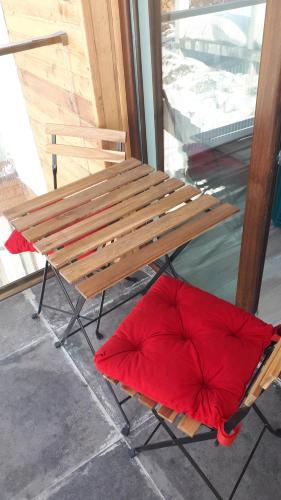 a wooden bench with a red pillow under it at New Gudauri, loft 2, Apartment 309, RED CO in Gudauri