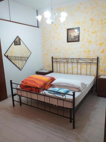 a bed with a metal frame in a room at Appartamento Marina in Marina di Carrara