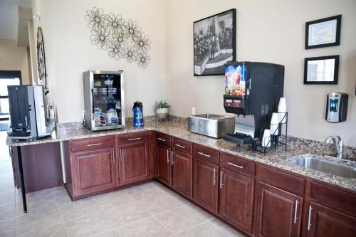 a kitchen with a counter with a sink and a tv at Cobblestone Inn & Suites -Clarinda in Clarinda