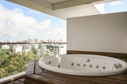 a bath tub in a room with a large window at Aizarker in La Plata