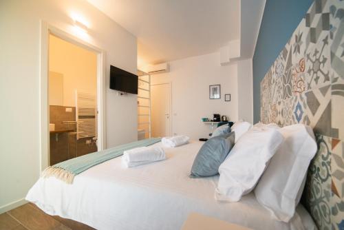 um quarto com uma cama grande e almofadas brancas em Casa Stazione em Verona