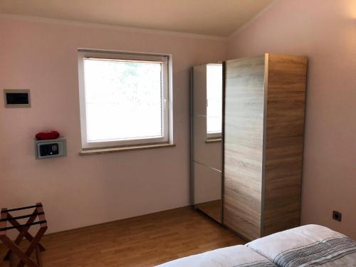 een slaapkamer met een houten kast en een raam bij Palme in Poreč