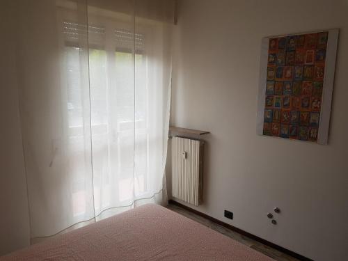 a white room with a window and a radiator at Foresteria Giulia in Bergamo