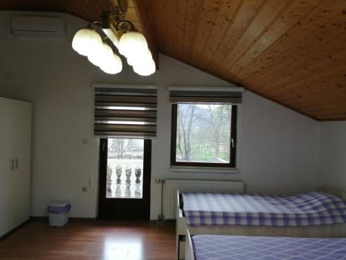 a bedroom with two beds and two windows at Amina River Apartment in Bihać