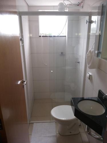 een badkamer met een douche, een toilet en een wastafel bij Apartamento Cidade Verde 6 MT in Maringá