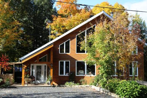 ein Holzhaus mit vielen Fenstern in der Unterkunft Le Gite A Margot in Bromont