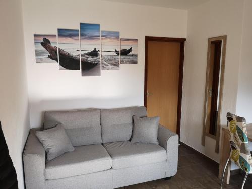 a living room with a couch and paintings on the wall at Holiday Home Cvitka in Vis