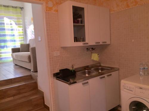 een keuken met een wastafel en een wasmachine bij Camere e Casa Vacanze in Misano Adriatico