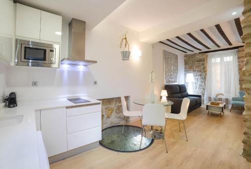 a kitchen and living room with a table and chairs at Palacio del Agua Apartamentos in Úbeda