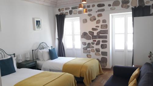 a hotel room with two beds and a window at Calcada Guesthouse in Tavira