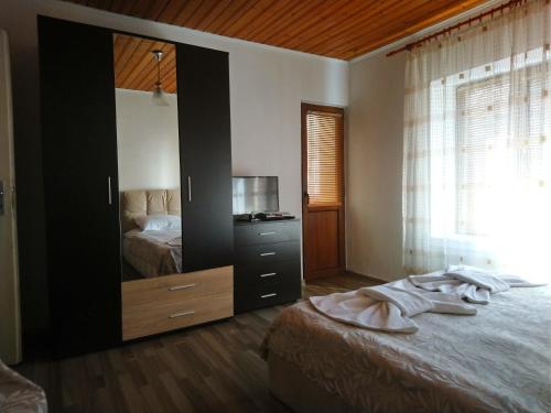 a bedroom with a bed and a dresser with a mirror at Guest house Emmy in Trigrad