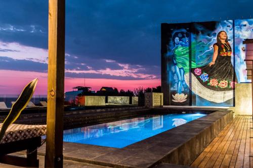 uma piscina no telhado de um edifício com uma pintura em Cabane Container Hotel - ADULTS ONLY em Puerto Escondido