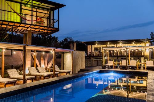 une piscine avec des chaises et un bâtiment dans l'établissement Cabane Container Hotel - ADULTS ONLY, à Puerto Escondido