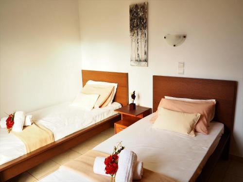 una camera con due letti e un tavolo con fiori di Casa di kampos ad Adelianos Kampos