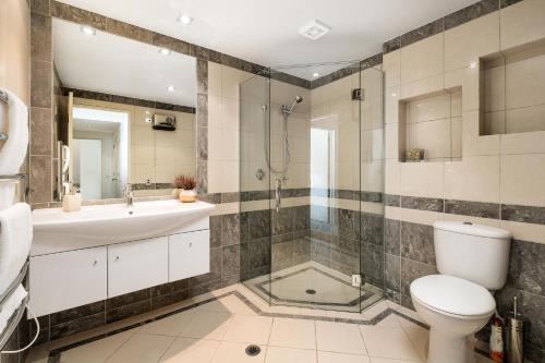 a bathroom with a shower and a toilet and a sink at Oriwa View in Queenstown