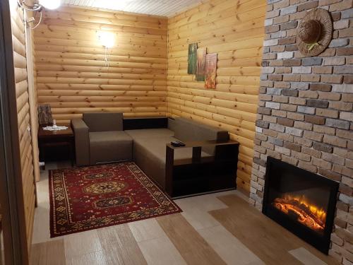 a room with a couch and a fireplace at Дом в лесу на берегу Днепра для отдыха с купелью на дровах, аппартоменты in Budishche