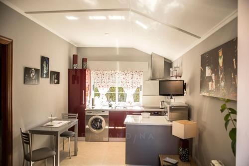 a kitchen with a table and a sink and a microwave at Apartamento Amieiro in Ribadeo