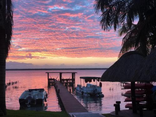 a sunset over a dock with boats in the water at Villa Marilu B&B in Bacalar