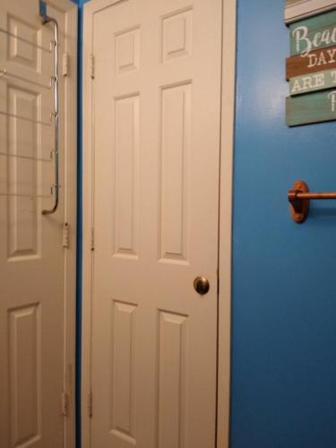 a white door in a room with a blue wall at Affordable SPI family condo - walking distance to the beach, Sleeps 6, Third Floor, 2025 Traveler Award in South Padre Island