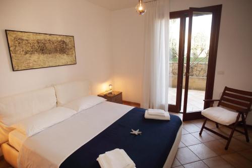 1 dormitorio con 1 cama, 1 silla y 1 ventana en Villa MarLu, en Bisceglie