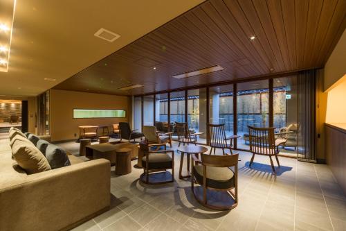 a lobby with a couch and tables and chairs at Oike Hotel in Fujikawaguchiko