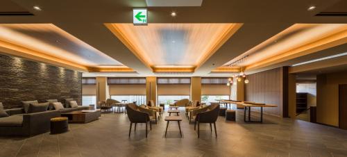 a hotel lobby with couches and tables and chairs at Oike Hotel in Fujikawaguchiko