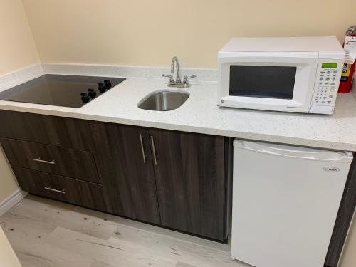 a kitchen with a sink and a microwave at King Hotel in Palmerston
