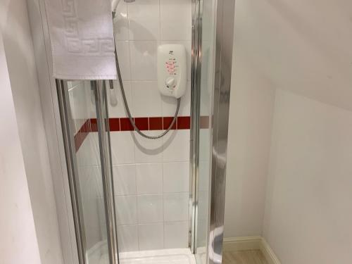 a shower in a bathroom with a phone on the wall at The Ivy in Wragby