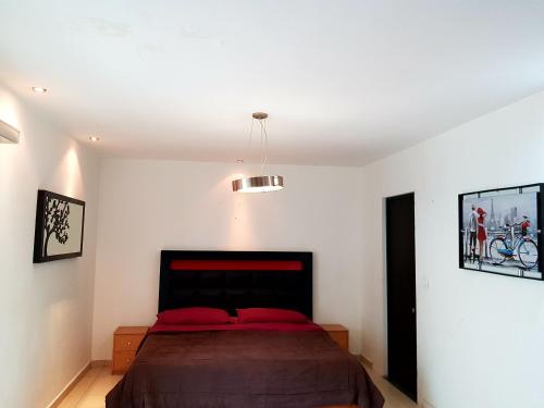 a bedroom with a large bed with red pillows at Contry La Silla Apartments zona tec - Nuevo Sur in Monterrey