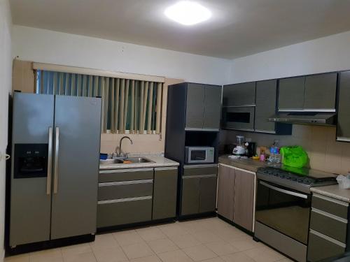 a kitchen with a stainless steel refrigerator and appliances at Contry La Silla Apartments zona tec - Nuevo Sur in Monterrey