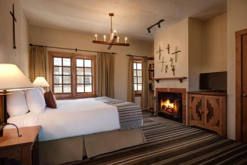 
a living room with a fireplace and a bed at Hotel Chimayo de Santa Fe in Santa Fe
