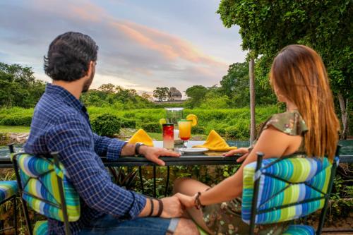 a man and a woman sitting at a table at Mayaland Hotel & Bungalows in Chichén-Itzá