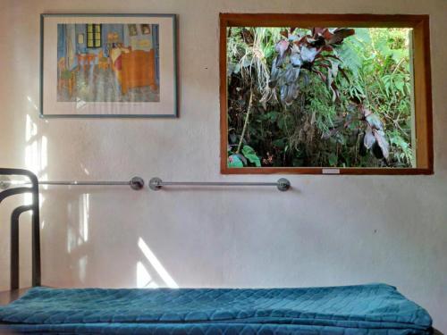 a bedroom with a bed and a picture on the wall at Chalé Gaia - Itatiaia in Itatiaia