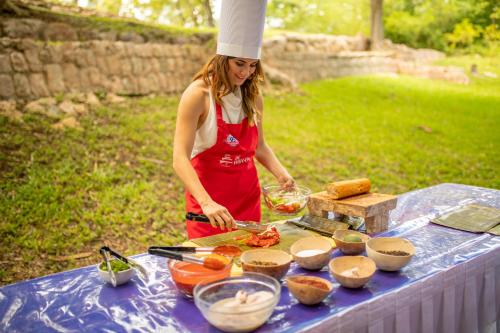 a woman is preparing food on a table at Mayaland Hotel & Bungalows in Chichén-Itzá