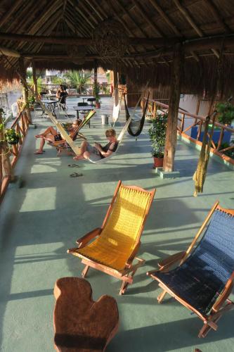 a group of people sitting in hammocks on a beach at Casa Almendro in Tulum