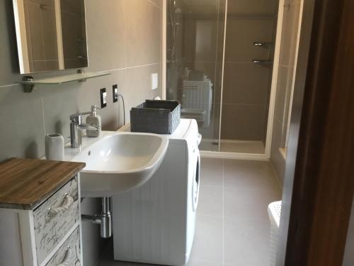 a white bathroom with a sink and a shower at Casa Claudia in Assenza di Brenzone