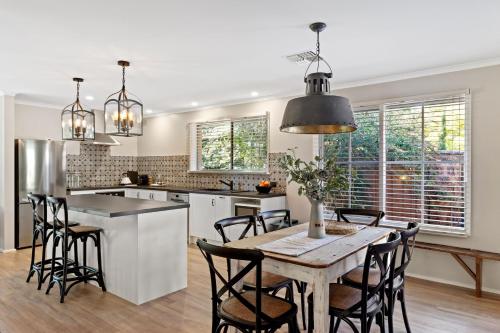 a kitchen with a wooden table and chairs at Adelaide Hills Retreats in Balhannah