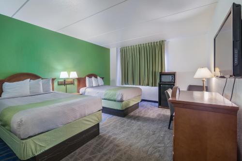 um quarto de hotel com duas camas e uma secretária em Badlands Inn & Suites em Dickinson