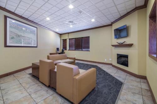 a waiting room with couches and a fireplace at Badlands Inn & Suites in Dickinson