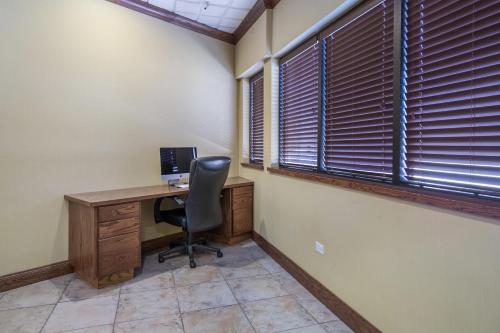 ein Büro mit einem Schreibtisch mit einem Computer und einem Fenster in der Unterkunft Badlands Inn & Suites in Dickinson
