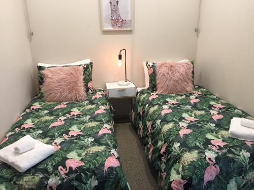 two beds in a small room with a bed sidx sidx sidx at Lake Terrace Apartment in Taupo