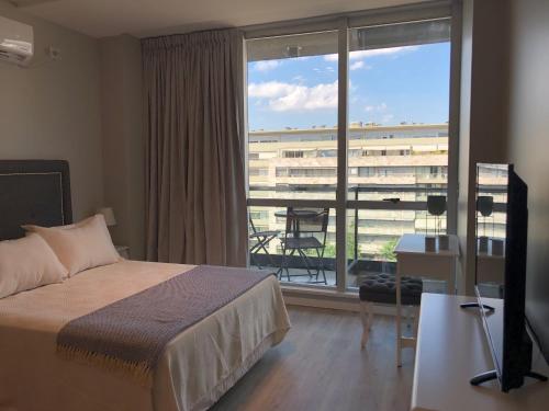 ein Hotelzimmer mit einem Bett und einem großen Fenster in der Unterkunft City Madero Buenos Aires in Buenos Aires
