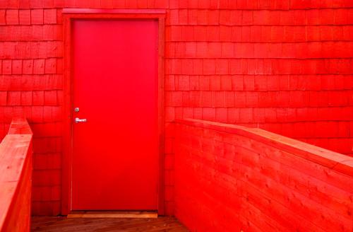 a red door in a red brick wall at Treehotel in Harads