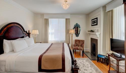 a hotel room with a bed and a television at The Inn at the Union Club of British Columbia in Victoria