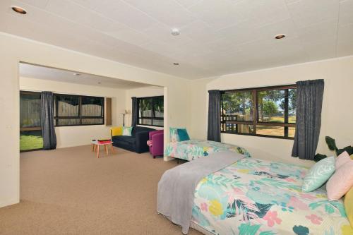 a bedroom with a bed and a couch at Ridge Haven Accommodation in Ruakaka