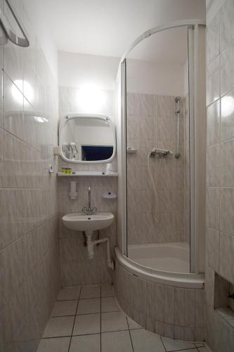 a small bathroom with a shower and a sink at Hotel Felix in Kraków