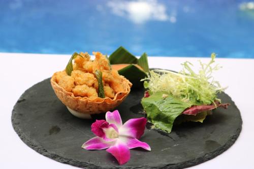 a plate with some food and a flower on it at Golden Temple Retreat in Siem Reap