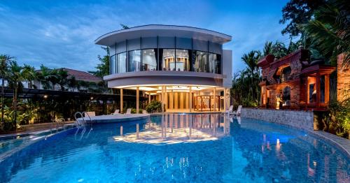 uma casa com piscina em frente a um edifício em Areca Resort and Spa - SHA Extra Plus em Kathu