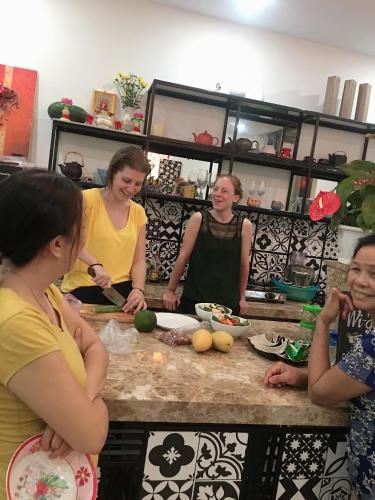 a group of women standing in a kitchen preparing food at Sunny Riverside Homestay in Hoi An