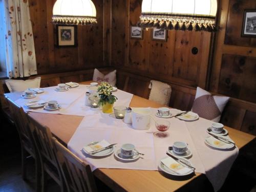 a table with a white table cloth on it at Pension der Steinbock - das 300 Jahre alte Bauernhaus - TIROL in Sankt Anton am Arlberg